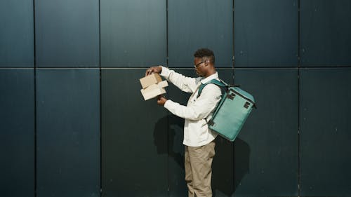 A Delivery Man Looking at Packages 