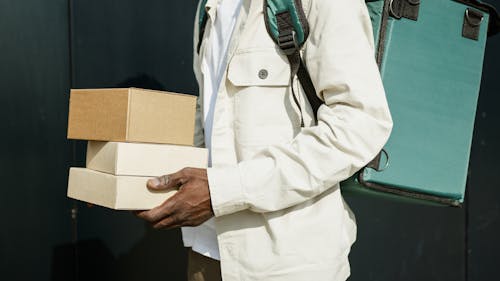 A Person Holding Brown Boxes