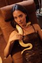 Woman in Black Spaghetti Strap Top Sitting on Brown Sofa