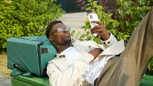 A Man Lying on the Bench while Using Smartphone