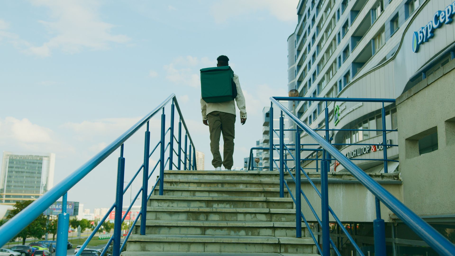Man Carrying a Delivery Bag Walking Up the stairs
