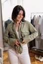 A Woman Holding the Bottom Hem of her Green Long Sleeve Shir