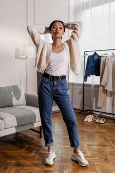Stylish Asian woman in casual clothing poses indoors with a modern fashion vibe.