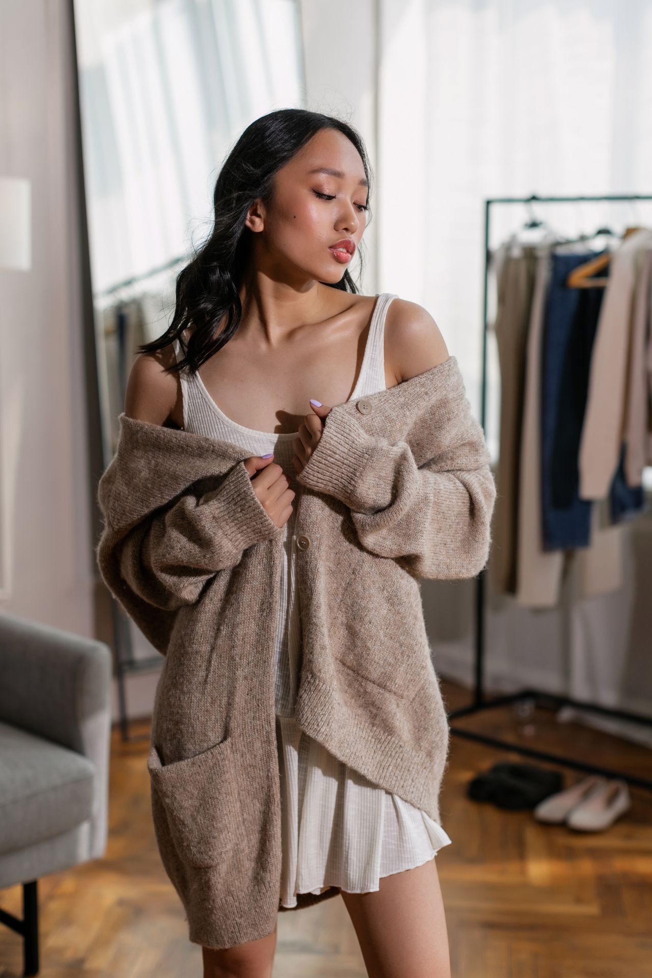 Oversized oatmeal chunky cardigan worn over a white dress
