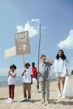 Family and children participating in a beach clean-up, holding save the earth signs.