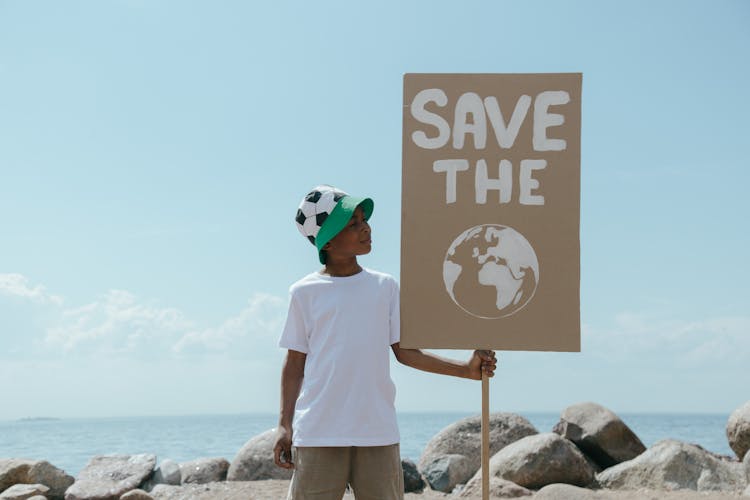 
A Boy Holding A Sign On A Beach