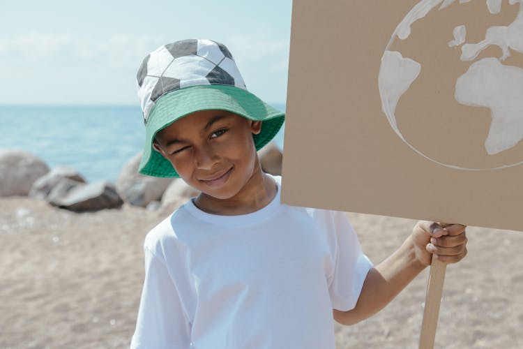 A Kid Holding An Earth Conservation PLacard