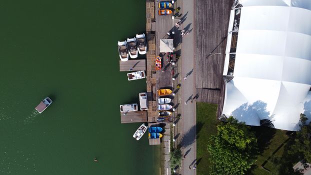 Drone shot capturing boats moored at a marina near white tent structure, Abrau-Dyurso, Russia.
