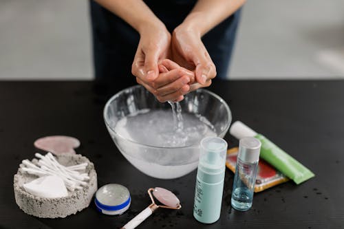 A Person Washing Her Hands on a Glass Bowl