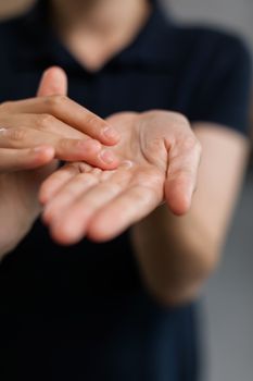 A detailed view of hands applying moisturizing cream, highlighting skincare routine.