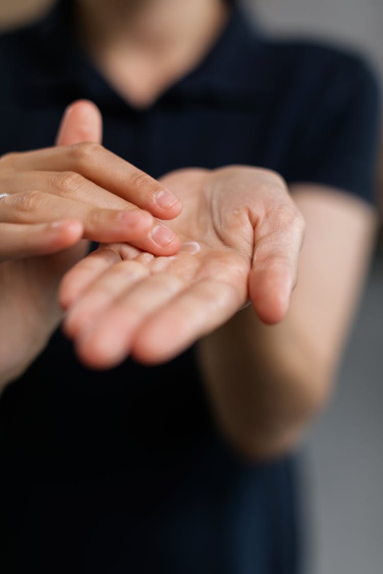 A Person Rubbing Cream On Palm