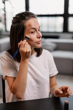 A woman uses a makeup brush to apply cosmetic products in a home interior.
