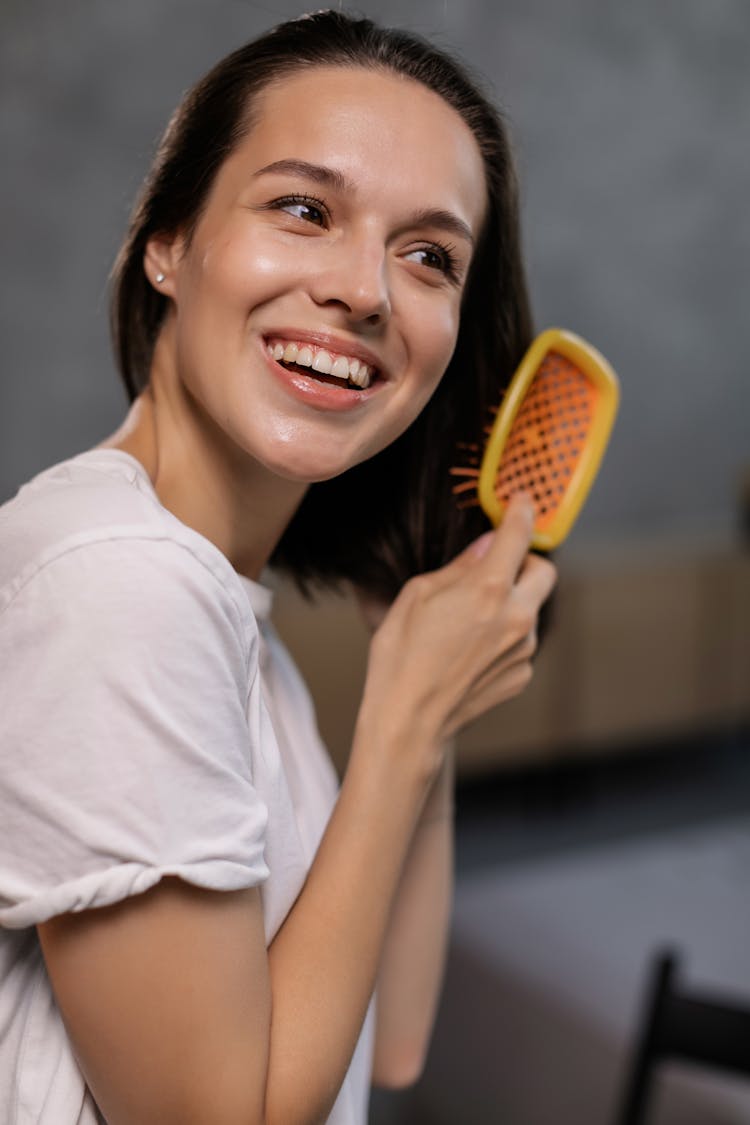 Woman In White T-Shirt Brushing Her Hair