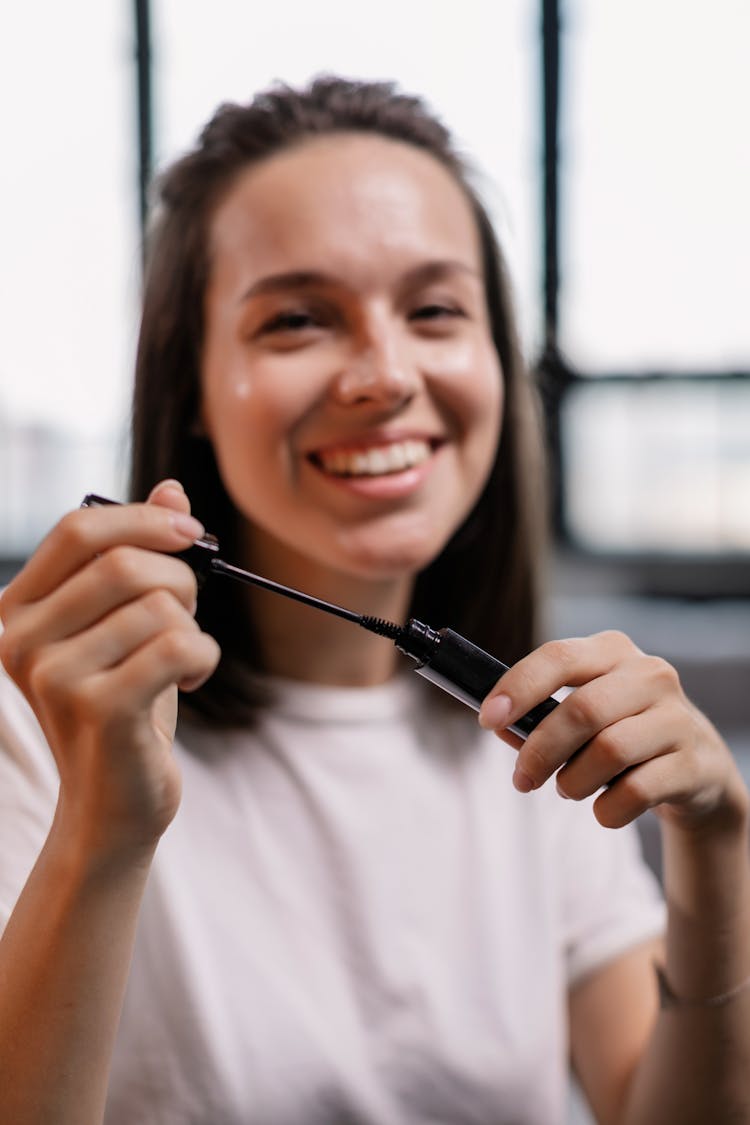 Smiling Woman Holding A Mascara Brush