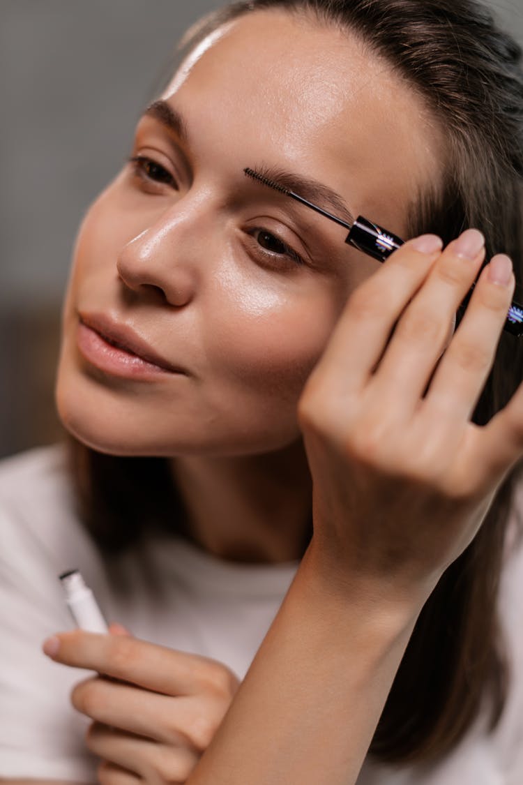 Woman Putting On Eyebrow Product