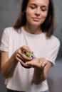 Woman in White Crew Neck T-shirt Holding Green Plastic Toy