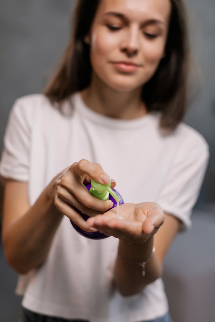 Woman Putting Lotion On Her Hand