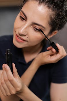 Close-up of a young woman applying mascara, showcasing beauty and makeup application.