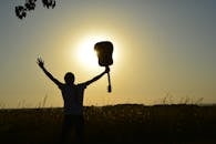 一位年轻的吉他手用原声吉他迎接日出，勾勒出戏剧性的轮廓