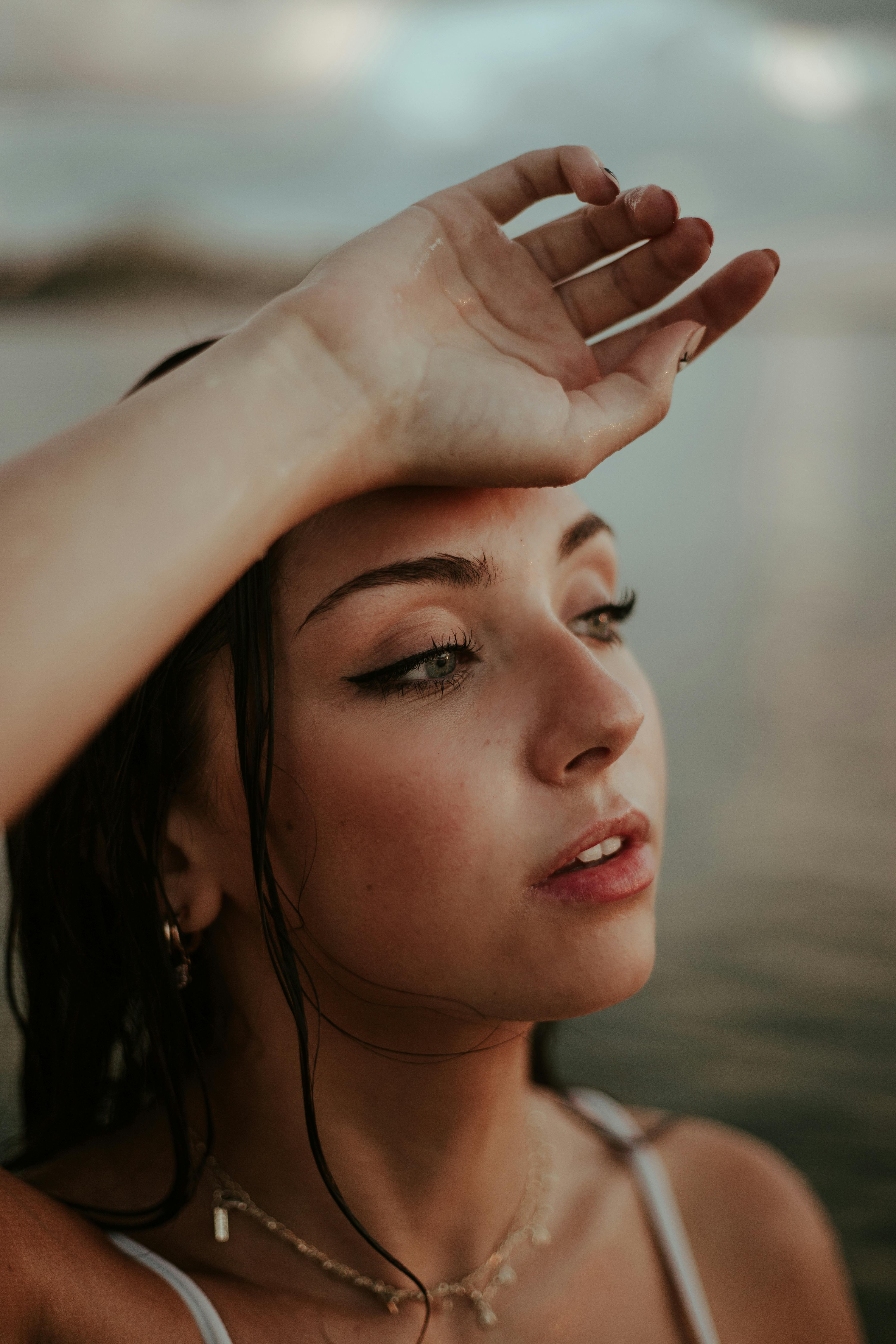 一个体贴的女人在暮色中凝视着海边的远方，营造出一种宁静的气氛