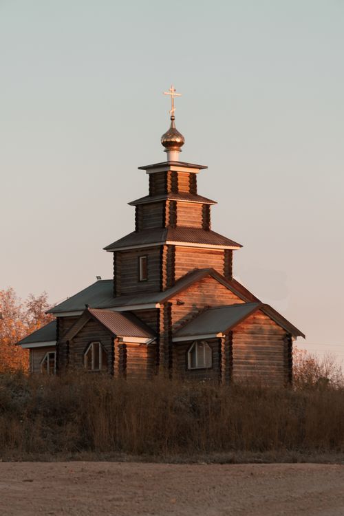 Free Charming wooden chapel in rural Udmurtia reflecting early morning sunlight, symbolizing peace. Stock Photo