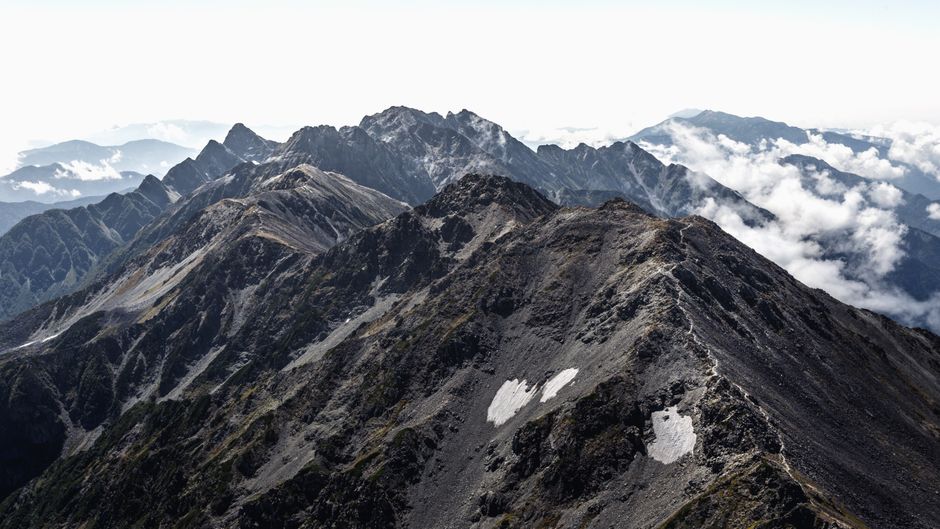 Breathtaking aerial view of the rugged Japanese mountain landscape under a cloudy sky.