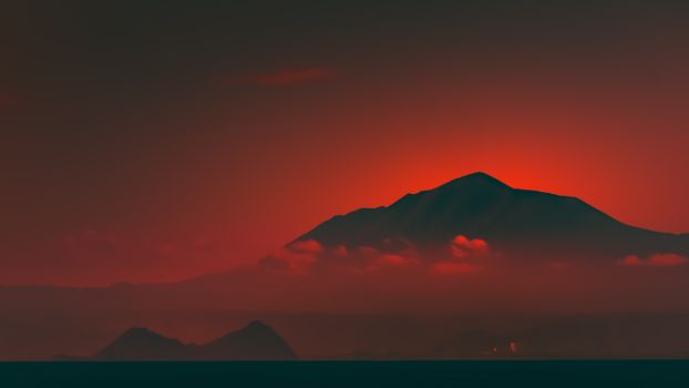 Silhouetted mountain at sunset in Japan with vivid red sky and clouds.
