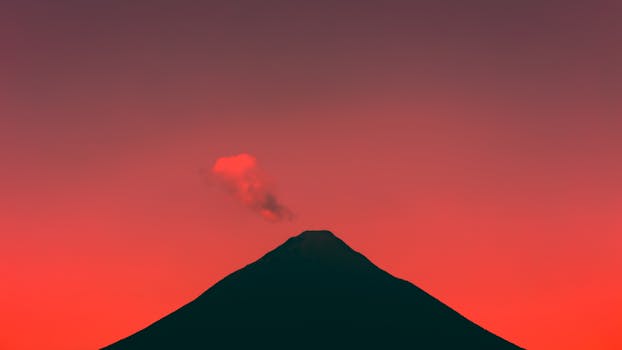 Stunning silhouette of Mount Fuji against a fiery sunset sky in Japan.