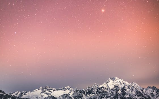 Stunning snowy mountain range beneath a starry sky in Italy, evoking serene beauty and wonder.