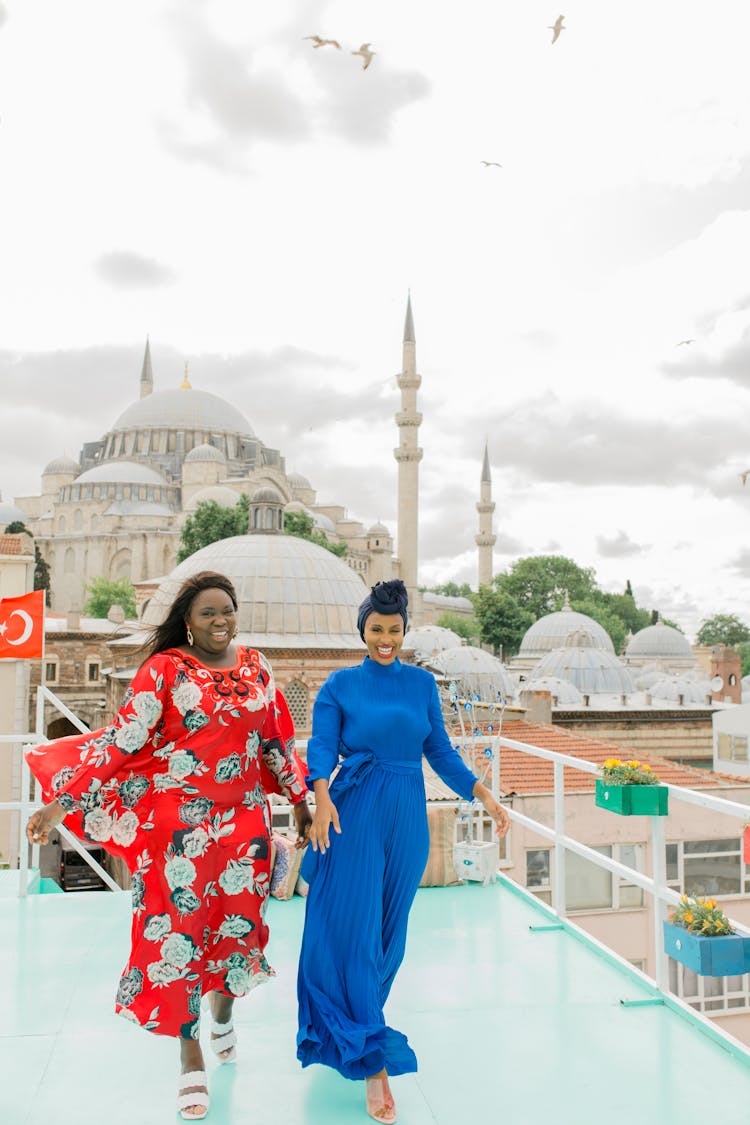 Women Walking On A Deck Near The Mosque