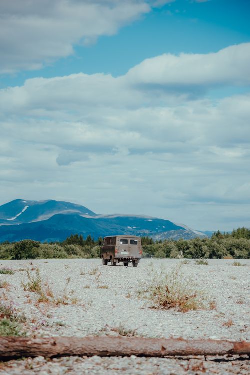 Free A rugged vehicle journeys through the remote, scenic expanses of Northwestern Russia under a bright blue sky. Stock Photo