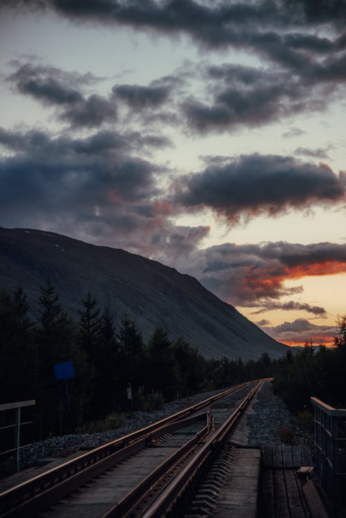 Railroad near Mountain during Sunset