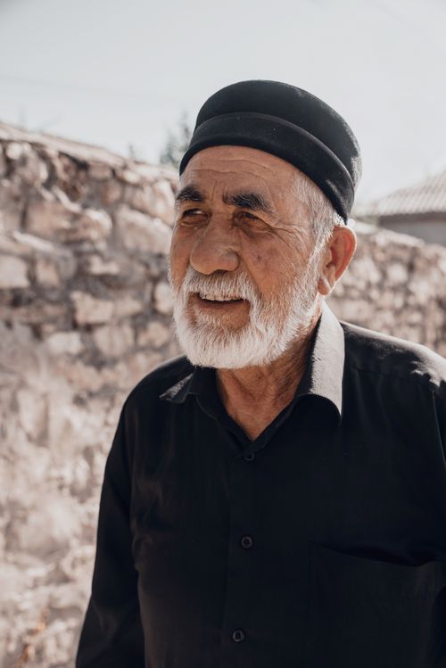 Free Portrait of a senior man with white beard and traditional hat outdoors in Dagestan. Stock Photo