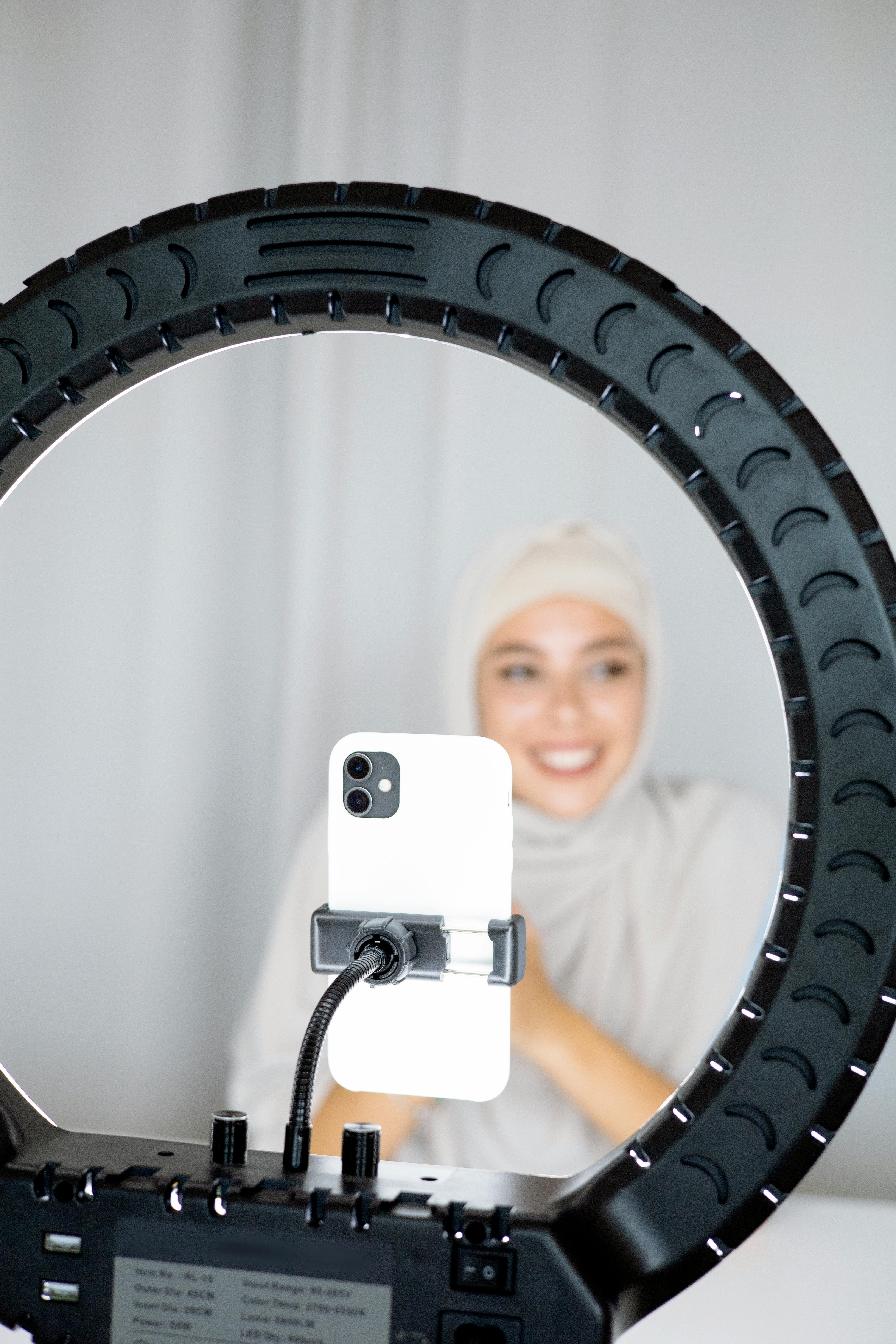woman using an iphone and ring light for vlogging