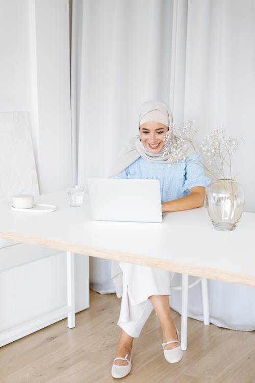 Woman in White Hijab Using White Laptop