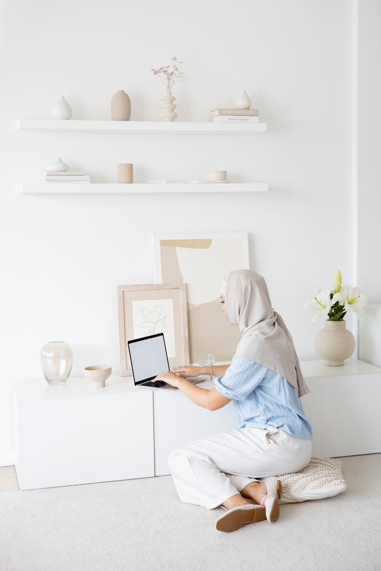 Woman In White Hijab Sitting On Floor While Using Laptop