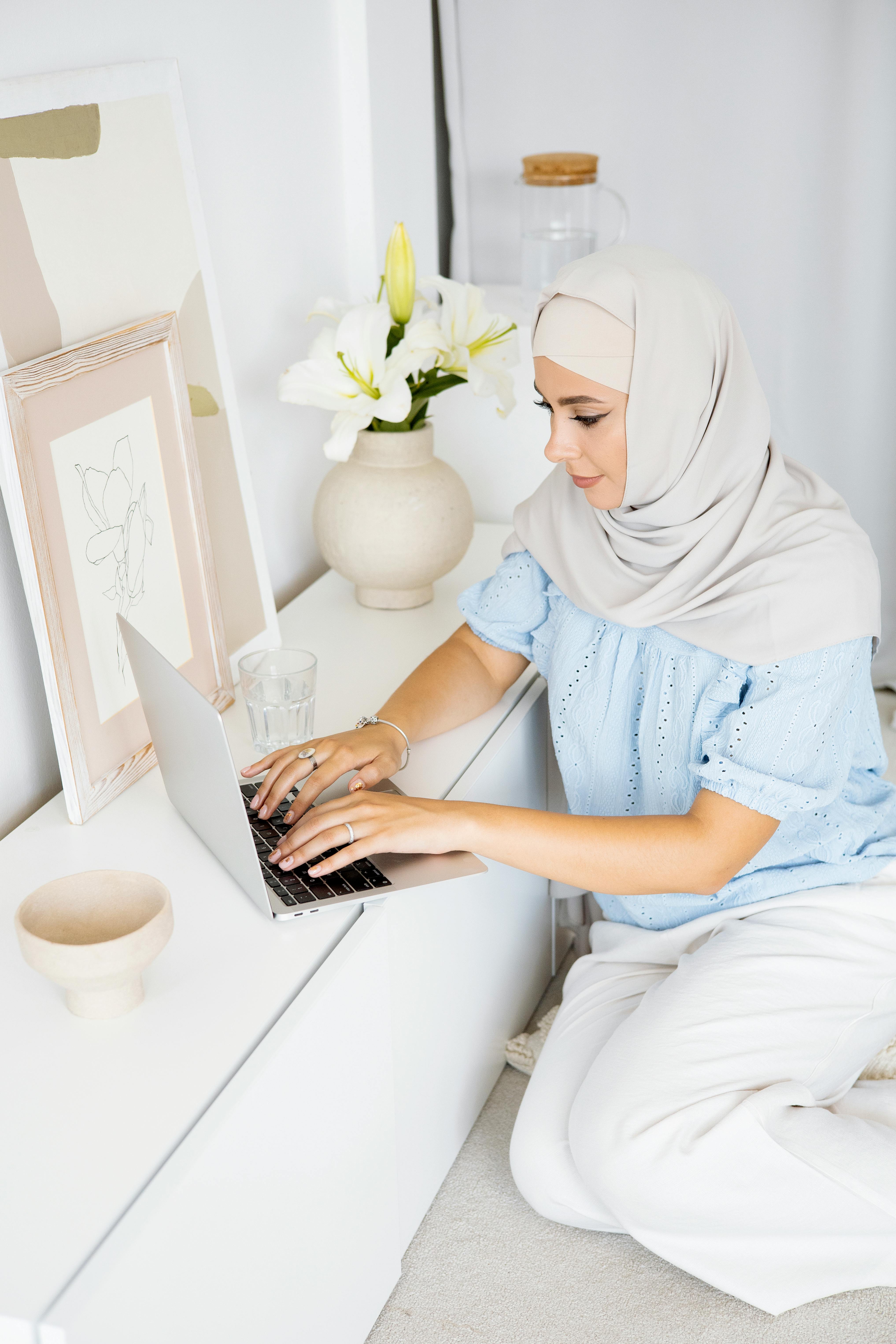 woman in blue blouse typing on the laptop