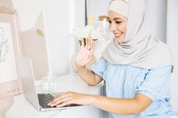 Woman in White Hijab Using Macbook Air