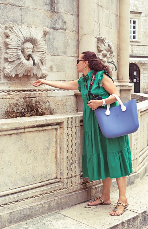Woman in Blue Dress Holding Blue Plastic Bucket