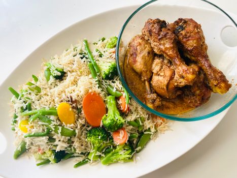 A delectable serving of grilled chicken with rice and mixed vegetables.