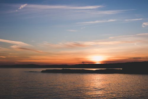 Free Beautiful ocean sunset with vibrant skies and serene waters, perfect for tranquil moments. Stock Photo
