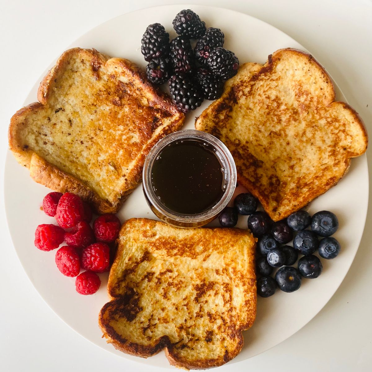 Golden French toast slices with berries and syrup ready to serve