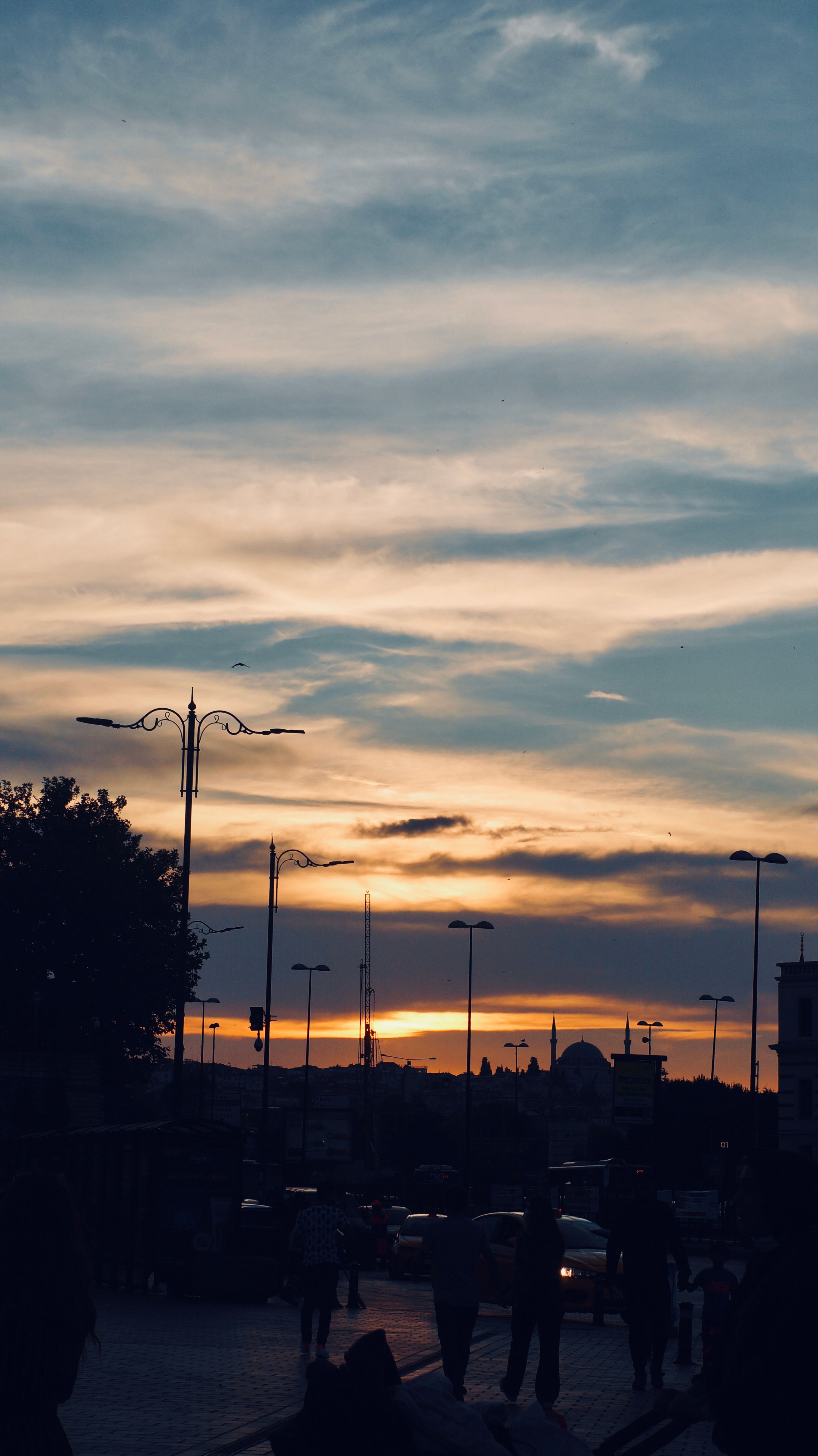 Silhouettes of People Walking down Street at Sunset · Free Stock Photo