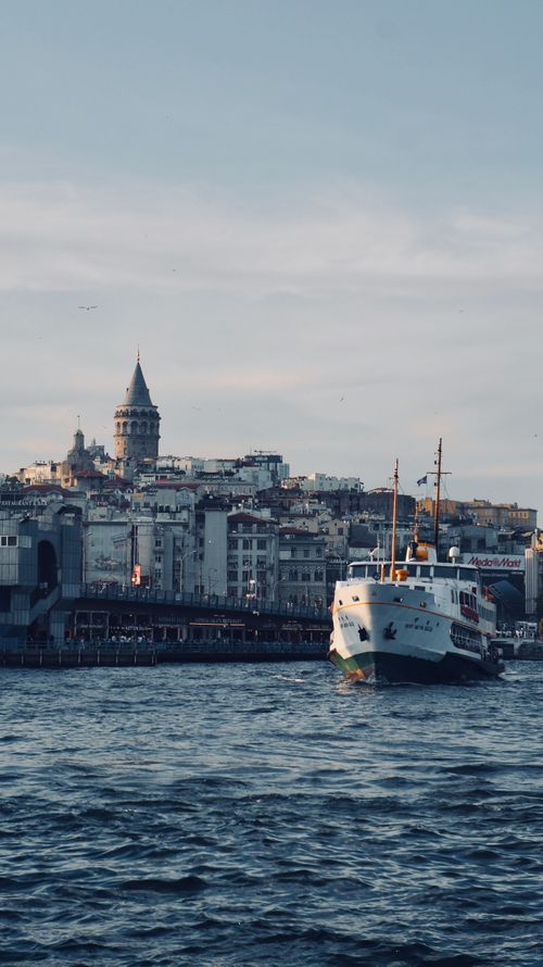 Free Ferry sailing in front of the historic Galata Tower and Istanbul skyline during the day. Stock Photo
