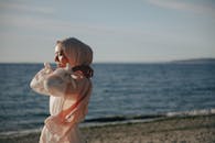 日落时，一个女人在头巾中捕捉到了宁静的海滨时刻