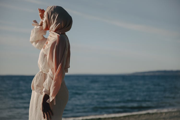 Woman In White Dress And Pink Hijab Looking At The Sea