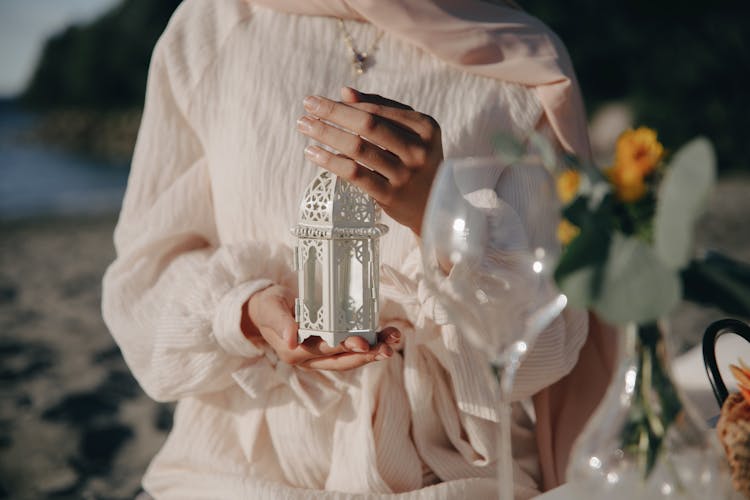 A Close-Up Shot Of A Woman Holding A White Lamp