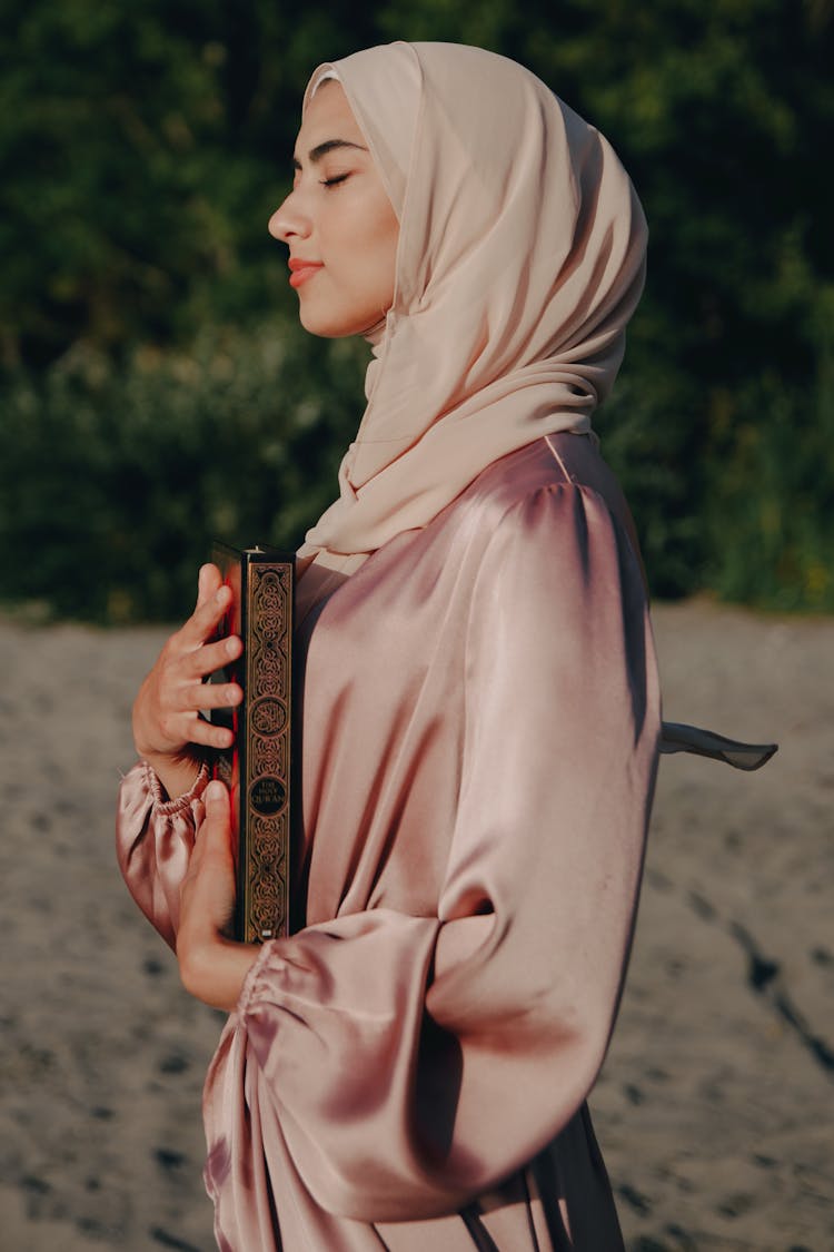 A Woman Holding A Quran 