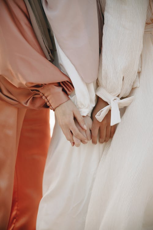 Women Wearing Dresses Holding Hands 