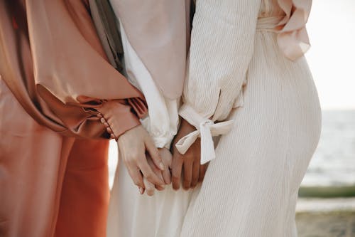 Women Wearing Dresses Holding Hands 